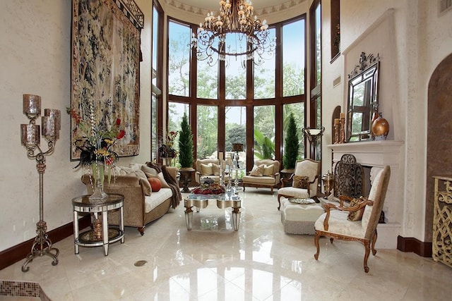 sitting room with a wealth of natural light, a chandelier, and a towering ceiling