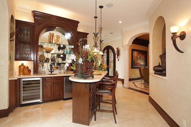 bar featuring ornamental molding, wine cooler, ornate columns, pendant lighting, and sink