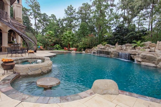 view of pool with a patio, pool water feature, and an in ground hot tub