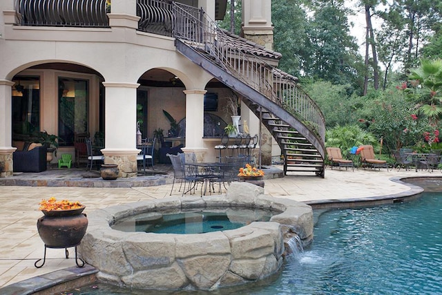 view of pool with a patio, pool water feature, and an in ground hot tub