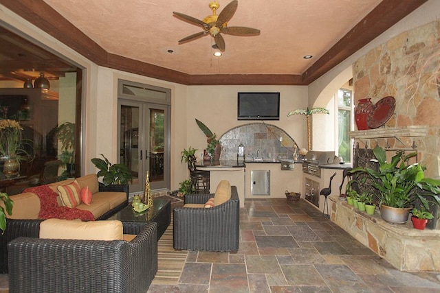 view of patio / terrace with ceiling fan, an outdoor hangout area, an outdoor kitchen, a grill, and french doors