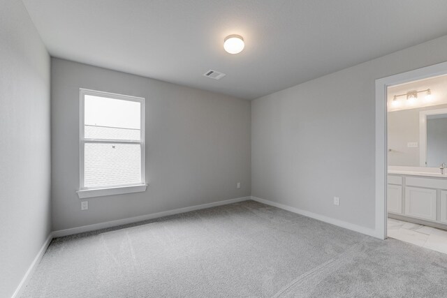 22126 Oceania Shores Dr, Hockley, TX 77447 - unfurnished bedroom with light carpet, a sink, baseboards, and ensuite bath