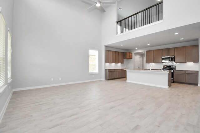 22126 Oceania Shores Dr, Hockley, TX 77447 - kitchen with stainless steel appliances, a ceiling fan, open floor plan, and a towering ceiling