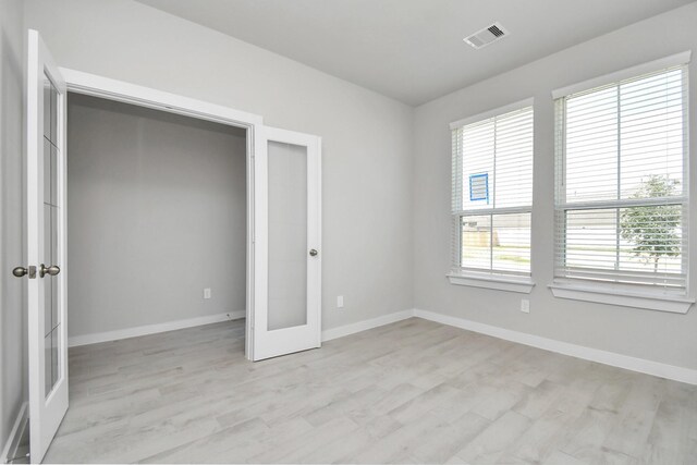 22126 Oceania Shores Dr, Hockley, TX 77447 - unfurnished bedroom with light wood-style floors, baseboards, and french doors