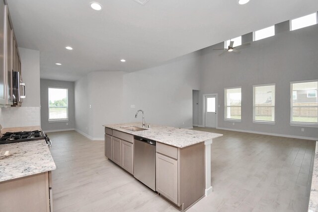 22126 Oceania Shores Dr, Hockley, TX 77447 - kitchen featuring stainless steel appliances, a sink, a ceiling fan, baseboards, and light wood-style floors
