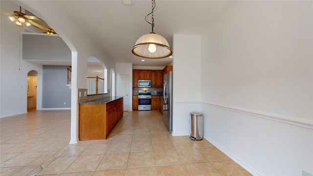 kitchen with stainless steel appliances, decorative backsplash, light tile patterned flooring, ceiling fan, and pendant lighting