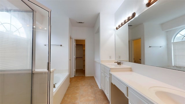 bathroom featuring vanity, tiled tub, and tile patterned floors