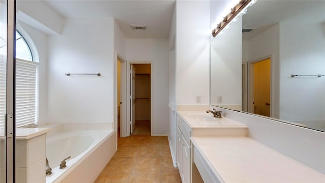 bathroom featuring vanity, tile patterned flooring, and a bathtub