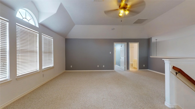 unfurnished living room featuring vaulted ceiling, light colored carpet, and ceiling fan