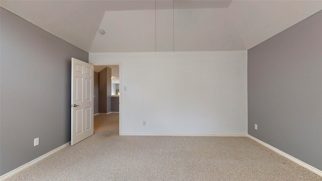 carpeted spare room featuring lofted ceiling