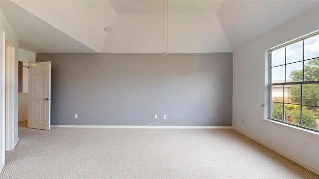 carpeted empty room featuring plenty of natural light and lofted ceiling