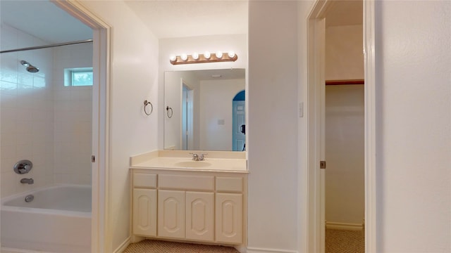 bathroom featuring tiled shower / bath and vanity