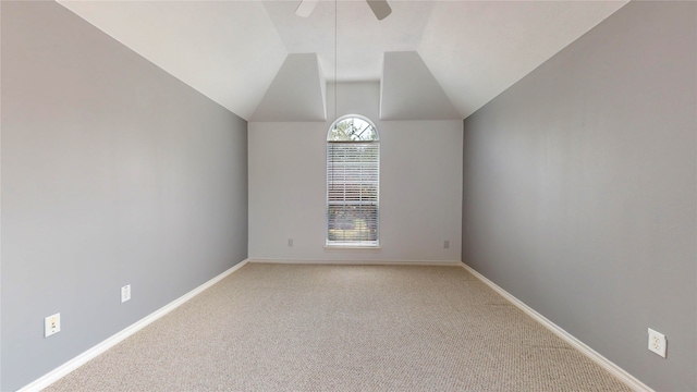 spare room featuring light colored carpet, ceiling fan, and vaulted ceiling