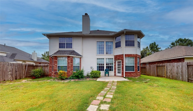 rear view of house featuring a lawn and a patio area