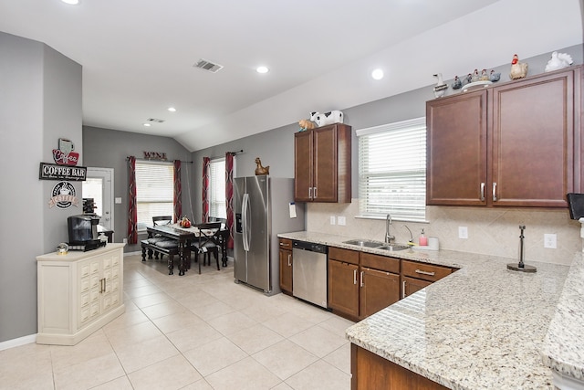 kitchen with stainless steel appliances, light tile patterned flooring, sink, tasteful backsplash, and lofted ceiling