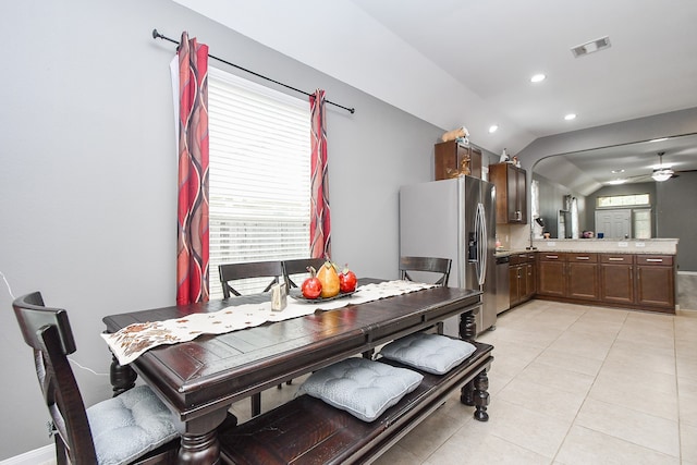 tiled dining space with ceiling fan and lofted ceiling