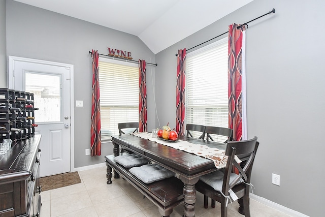 dining area with lofted ceiling, light tile patterned floors, and plenty of natural light