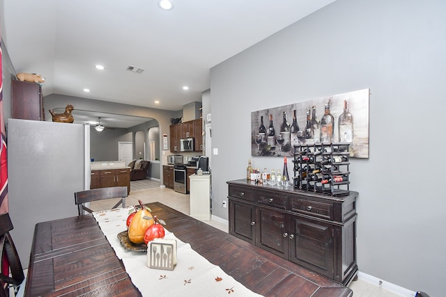 dining space with ceiling fan and bar area