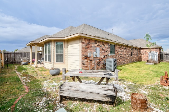 rear view of house with a yard and cooling unit