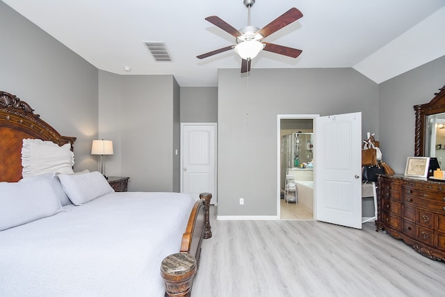 bedroom with light wood-type flooring, lofted ceiling, ceiling fan, and connected bathroom