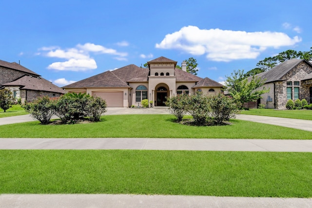 mediterranean / spanish-style home featuring a garage and a front lawn