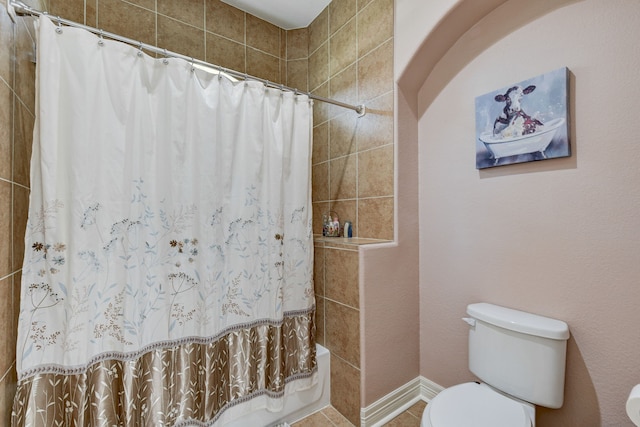 bathroom with toilet, shower / bath combo, and tile patterned flooring