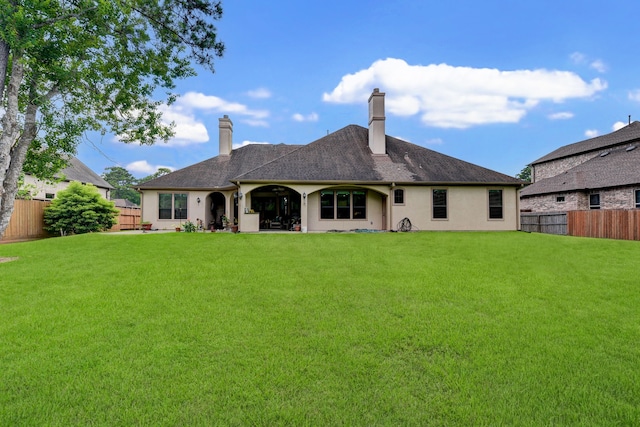 back of property featuring a yard