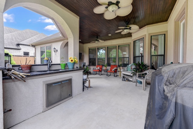 view of patio featuring an outdoor kitchen, ceiling fan, and sink