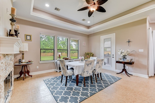 dining room featuring light tile patterned flooring, a tray ceiling, ceiling fan, and crown molding