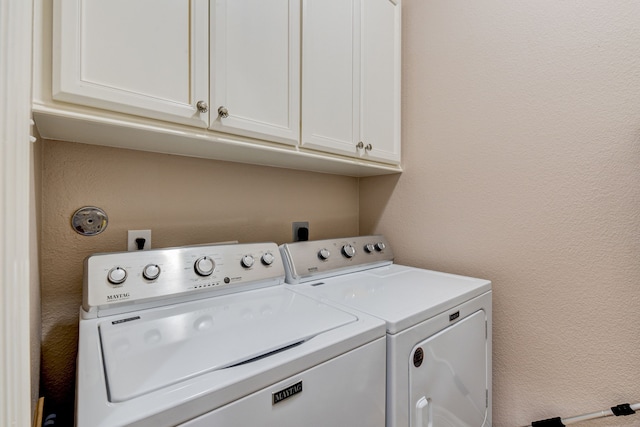 laundry room featuring cabinets and washer and dryer