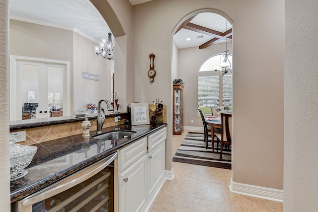 bar with light tile patterned flooring, wine cooler, white cabinetry, beam ceiling, and sink