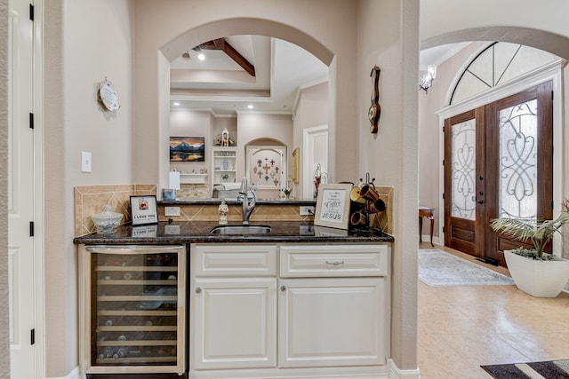 bar featuring sink, beam ceiling, white cabinetry, dark stone countertops, and wine cooler