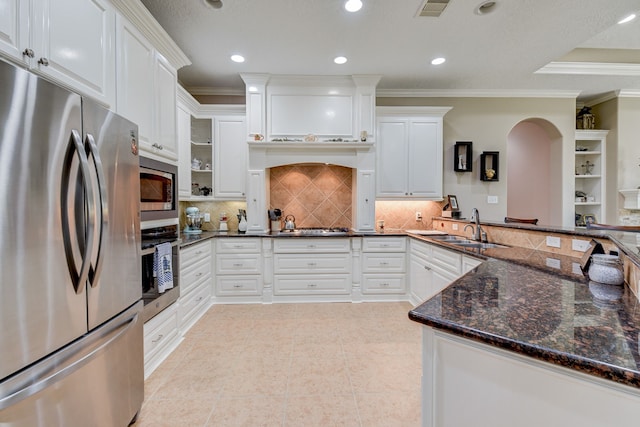 kitchen with crown molding, stainless steel appliances, sink, white cabinets, and dark stone countertops