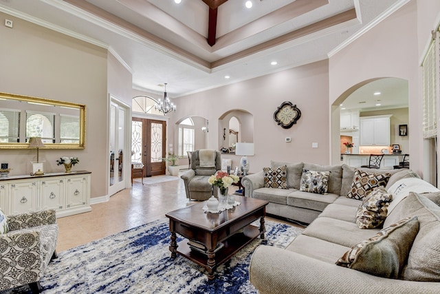 living room with french doors, a towering ceiling, a notable chandelier, light tile patterned floors, and ornamental molding