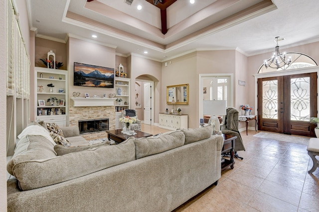 tiled living room featuring built in shelves, french doors, ornamental molding, and a chandelier