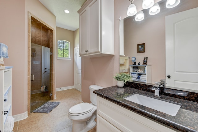 bathroom featuring vanity, a shower with shower door, tile patterned floors, and toilet