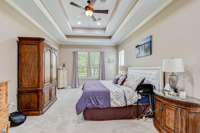 bedroom with ceiling fan, ornamental molding, a tray ceiling, and light colored carpet