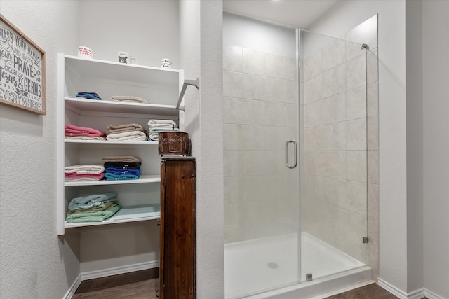 bathroom featuring hardwood / wood-style flooring and a shower with shower door