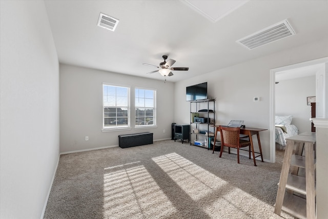 carpeted home office featuring ceiling fan