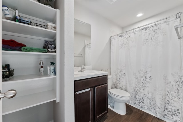 bathroom featuring toilet, vanity, and hardwood / wood-style flooring