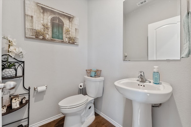 bathroom with hardwood / wood-style flooring and toilet