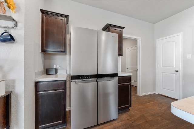 kitchen with dark brown cabinets, stainless steel fridge, and dark hardwood / wood-style floors