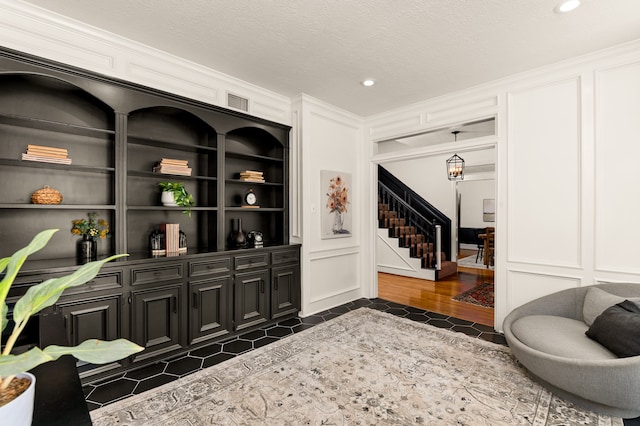 sitting room with dark hardwood / wood-style flooring, built in features, and a textured ceiling