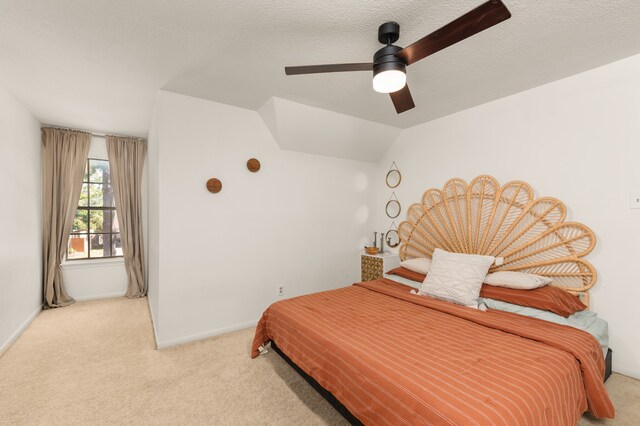 carpeted bedroom with lofted ceiling, ceiling fan, and a textured ceiling