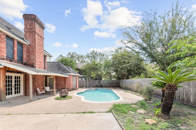 view of swimming pool featuring a patio area and french doors