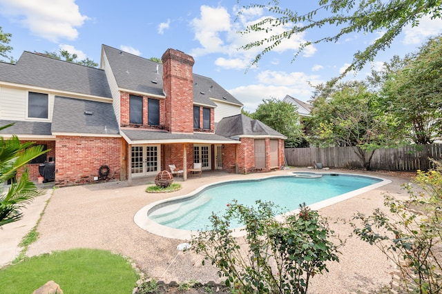 view of pool with an in ground hot tub, french doors, and a patio