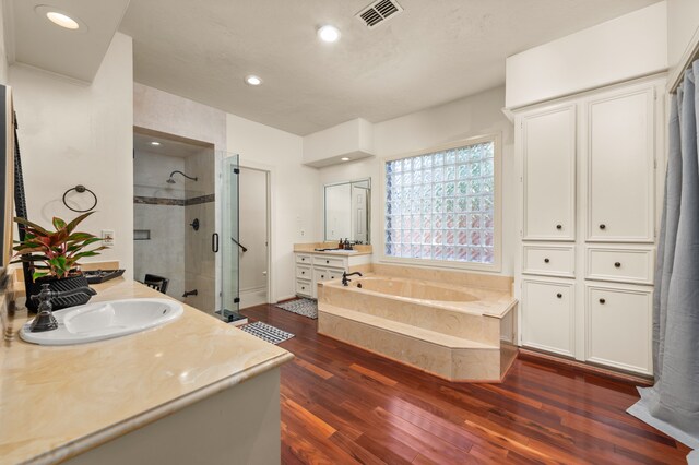 bathroom with plus walk in shower, vanity, and hardwood / wood-style flooring