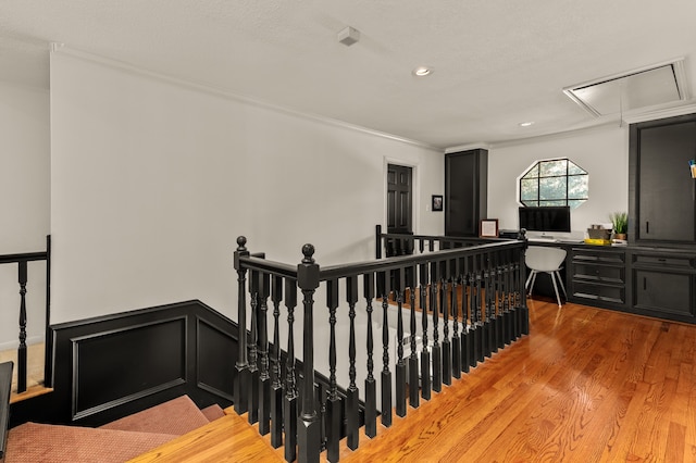 stairs with hardwood / wood-style floors and crown molding