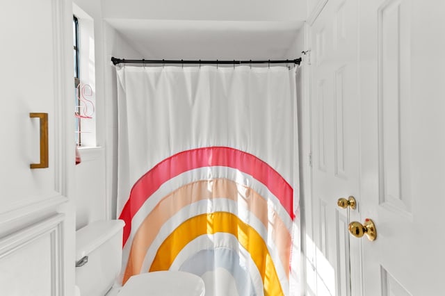 bathroom featuring a shower with curtain and toilet