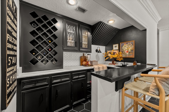 bar featuring a textured ceiling, crown molding, lofted ceiling, and backsplash